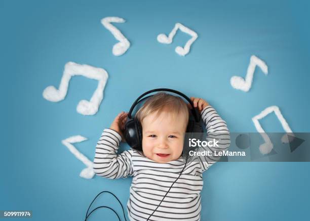 Little Boy On Blue Blanket Background With Headphones Stock Photo - Download Image Now