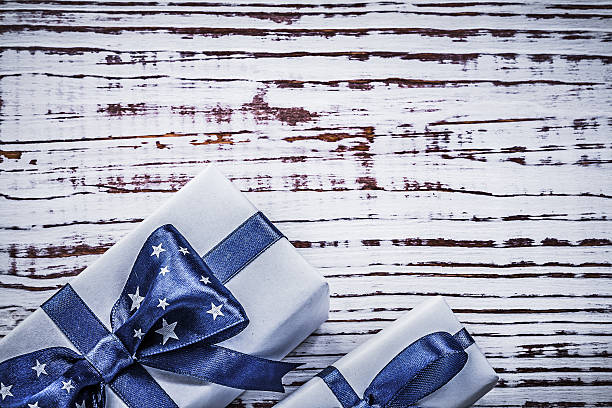 istock Gift containers with blue present tapes on vintage wooden board 509915464