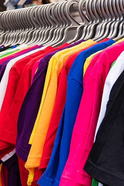 istock Various colored T-shirts on hangers 509915610