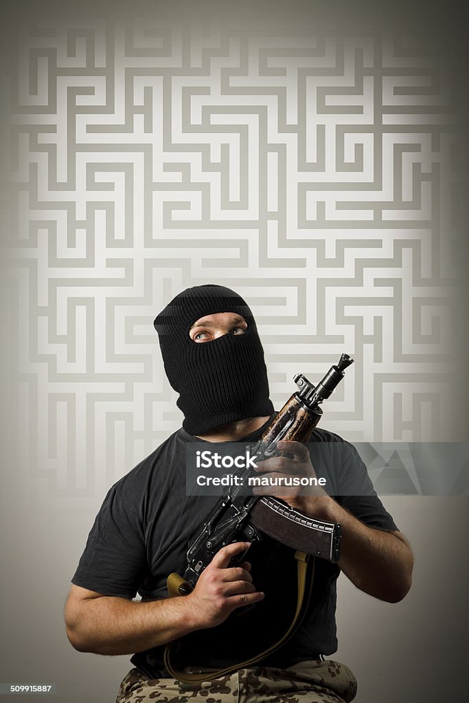 Man with gun and maze. Man in mask with gun solving maze. Maze concept. Adult Stock Photo