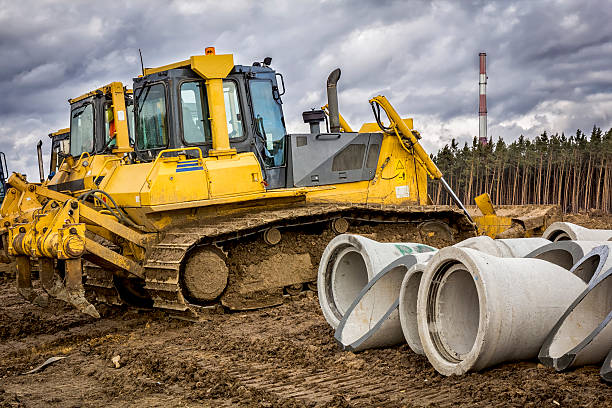 istock Concrete drainage pipes and bulldozers 509916142