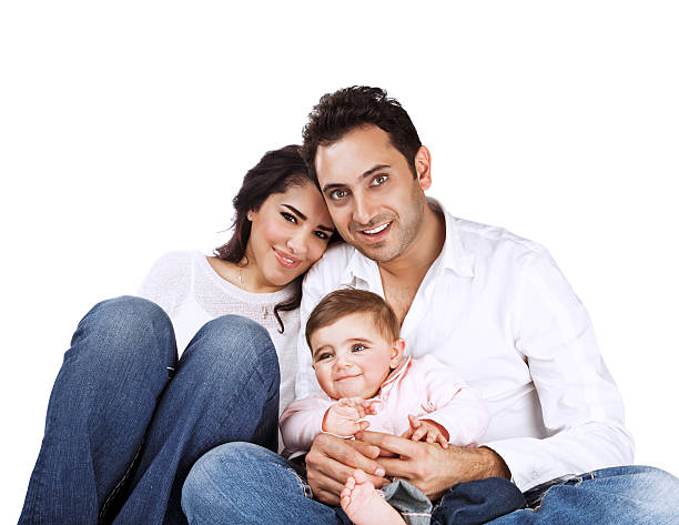 Portrait of young family isolated on white background, cheerful parents with cute baby posing in the studio, togetherness concept
