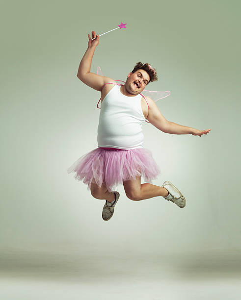 Showing his lighter side! An overweight man comically dressed-up in a pink fairy costume fairy photos stock pictures, royalty-free photos & images