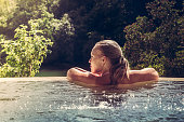 Woman relaxing in hotel  swimming pool looking at view