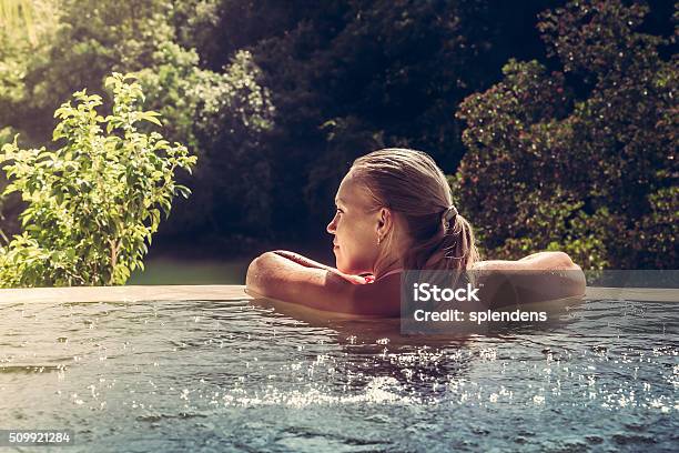 Woman Relaxing In Hotel Swimming Pool Looking At View Stock Photo - Download Image Now