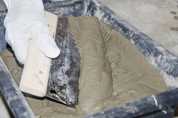 istock Tiler taking tile adhesive with a notched trowel 509921293