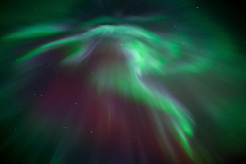 Aurora Borealis directly overhead in a dark night sky.