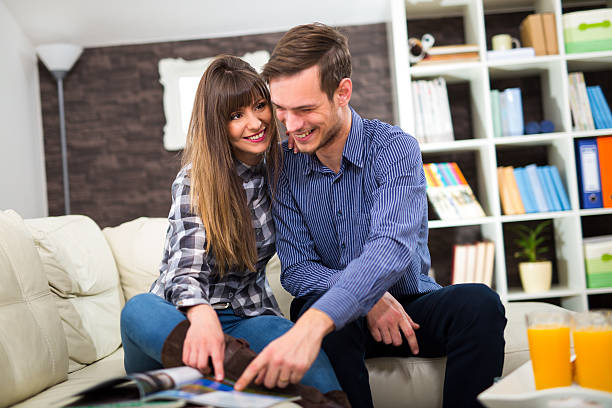istock Couple reading a magazine at home. 509921626