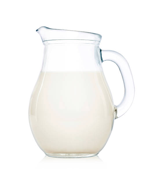 Glass jug of milk isolated on white