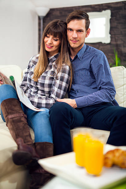 istock Couple reading a magazine at home. 509923900