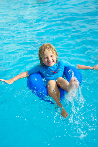 Smiling little boy during summer vacation in the swimming pool
