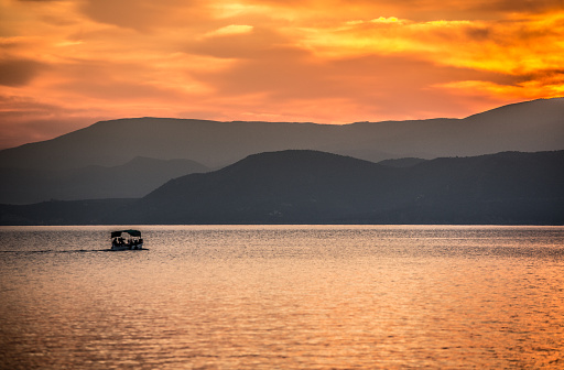 Sunset over the Pelion mountains, region of Thessaly, in Central Greece. A boat is visible in the image.