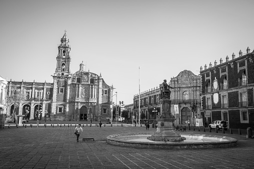 Mexico City, Mexico - October 29, 2014: Early in the morning, people walk across Plaza Santo Domingo in the Centro Historico area of Mexico City, Mexico. In the background is the Church of Santo Domingo.