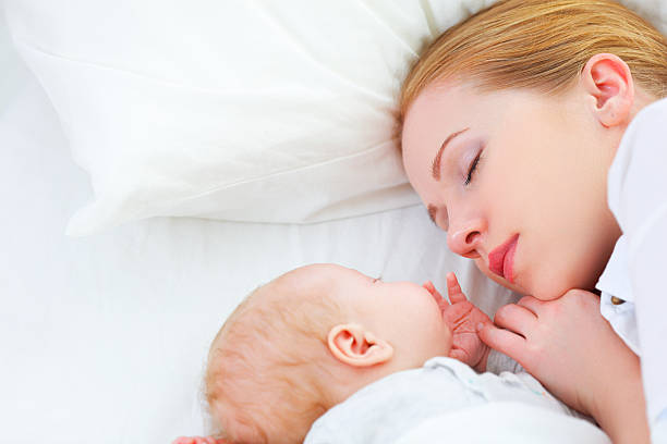 istock newborn baby and mother sleeping together 509927276
