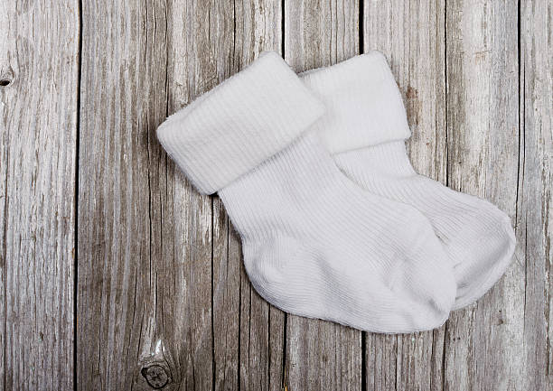 istock White baby socks on a wooden 509927300