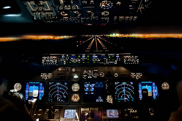 Final approach at night - landing plane flight deck view Final approach at night - landing of a jet airliner, view from the cockpit piloting photos stock pictures, royalty-free photos & images
