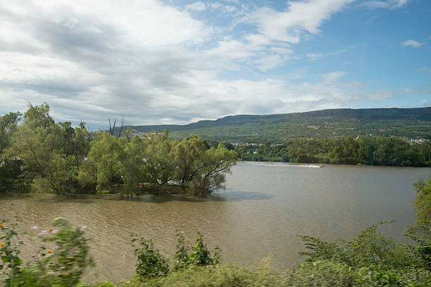 A motorboat with tourists speeds down the Grijalva River near Chiapa de Corzo in Chiapas, Mexico. Photo taken from a moving bus.