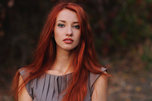 Outdoors portrait of beautiful young woman with red hair colorful autumn