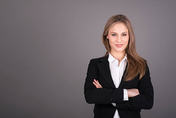 Portrait of wonderful young business woman  with copy space Portrait of wonderful young business woman on gray background with copy space costantino stock pictures, royalty-free photos & images