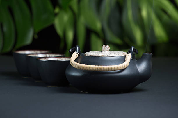 istock Black ceramic teapot with cups and steam 509931468