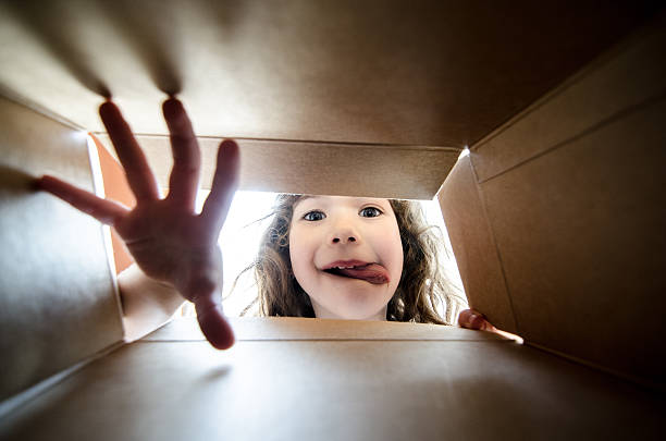 istock Happy girl taking a cookie in box from inside 509932574