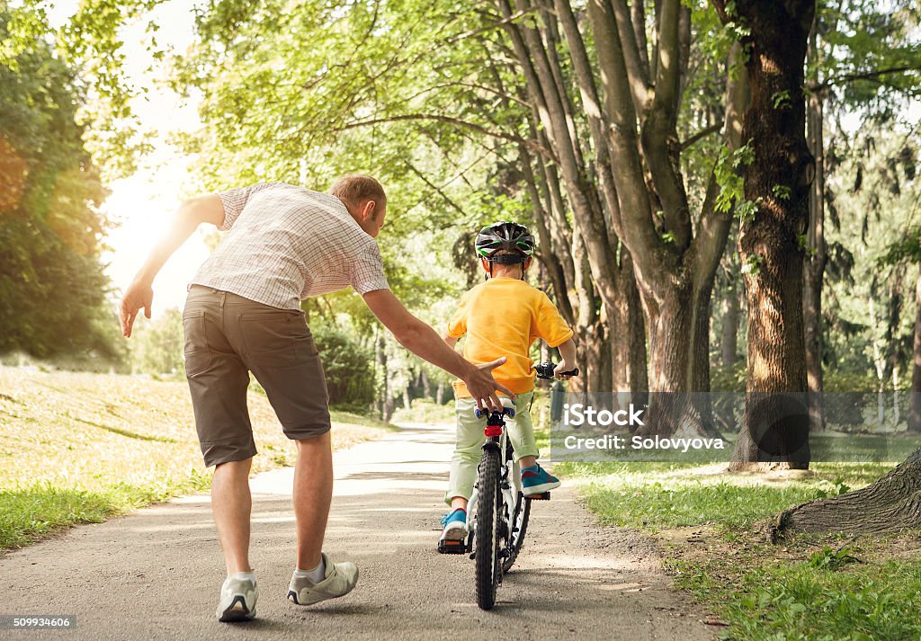 Father learn his little son to ride a bicycle Bicycle Stock Photo