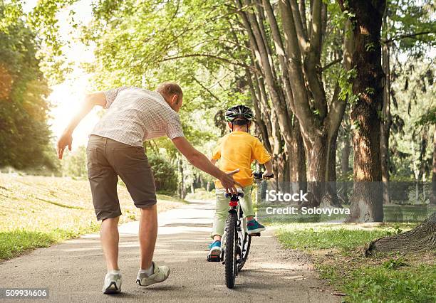 Father Learn His Little Son To Ride A Bicycle Stock Photo - Download Image Now - Bicycle, Father, Lifestyles