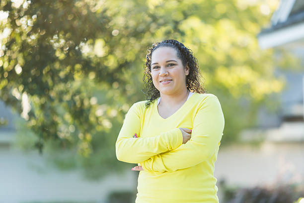 istock Hispanic woman standing outdoors with arms folded 509936108