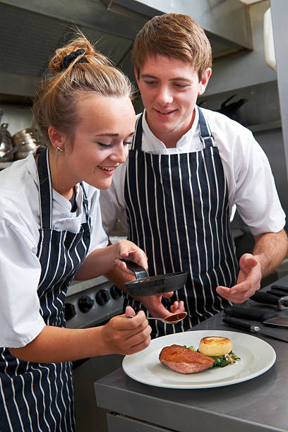 шеф-повар instructing стажёр в ресторане kitchen - chef trainee cooking teenager стоковые фото и изображения