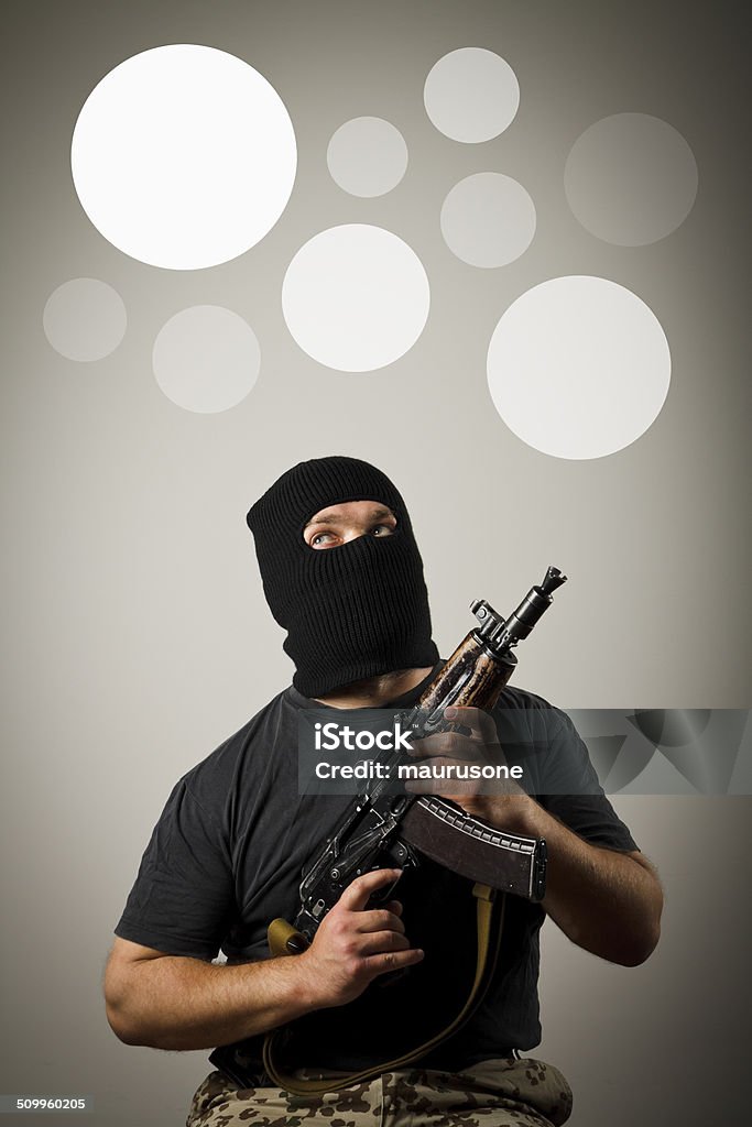 Man with gun. Gray bubbles. Man in mask with gun having an idea with gray bubbles over his head. Adult Stock Photo