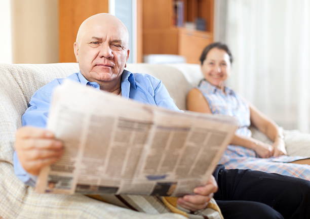 istock mature couple together with newspaper 509961057