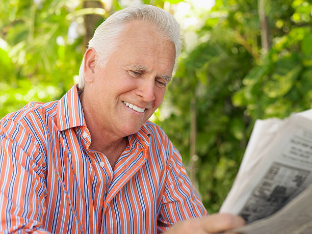 istock Smiling Mature Man Reading Newspaper 509979563