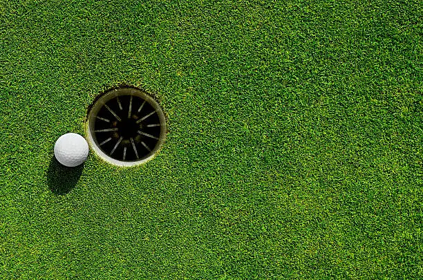Close up of a golf ball close to the hole