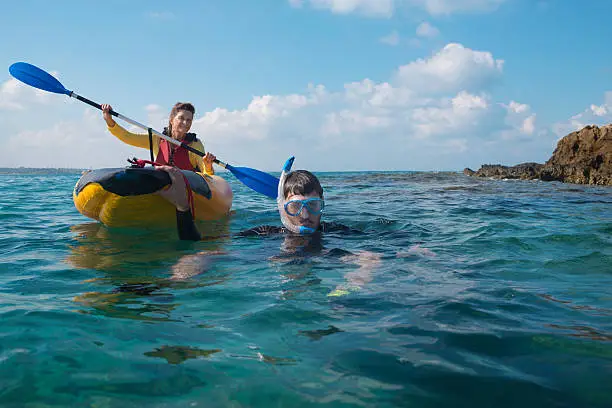 Family kayaking and snorkeling in Mediterranean Sea.