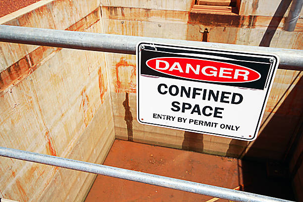 Confined Space Pit A confined space safety sign in an industrial application barricade photos stock pictures, royalty-free photos & images