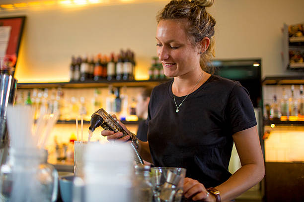 istock Female bartender using soft drink spirit mixer behind the bar 509990094