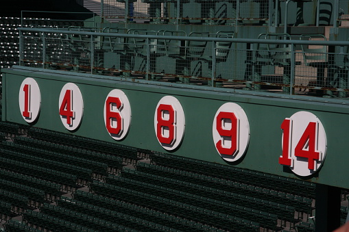Boston , Ma USA   September 19, 2009  Retired numbers from players of the Boston Red Sox in the famed Fenway Park which is a team in the American League of major league baseball . Fen way Park is located in the city of Boston 