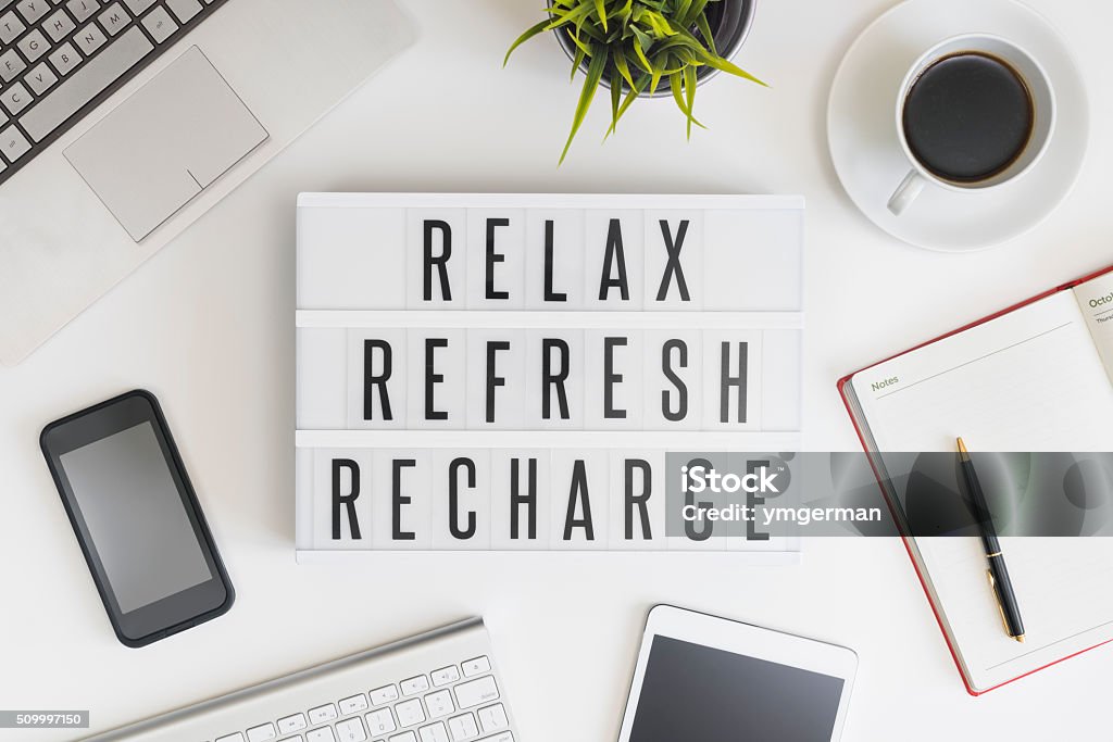 Relax, refresh and recharge in office Relax, refresh and recharge words on office table with computer, coffee, notepad, smartphone and digital tablet Relaxation Stock Photo