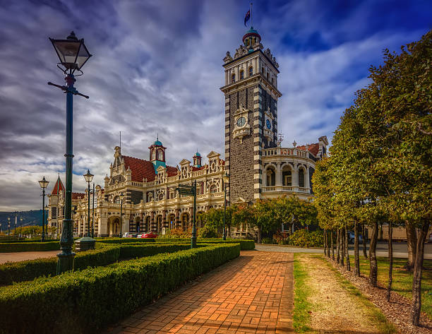 Footpath Leading To Train Station, Dunedin HDR Photography, shot in March during Autumn. Dunedin Railway Station in Dunedin on New Zealand's South Island, designed by George Troup, is the city's fourth station. It earned its architect the nickname of "Gingerbread George". dunedin new zealand stock pictures, royalty-free photos & images