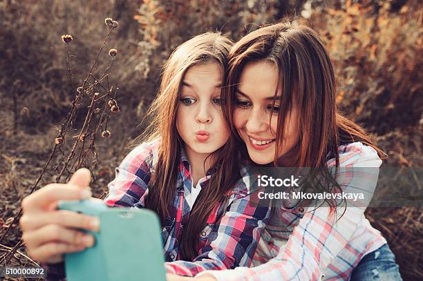 Feliz Madre E Hija Haciendo Autofoto Al Aire Libre En Verano Foto de stock y más banco de imágenes de Adolescente