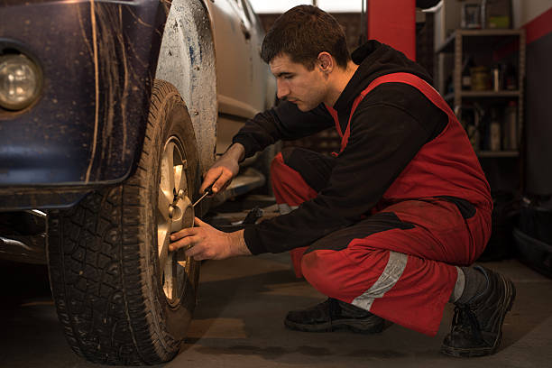 istock Auto mechanic working on a car tire in a workshop. 510003230