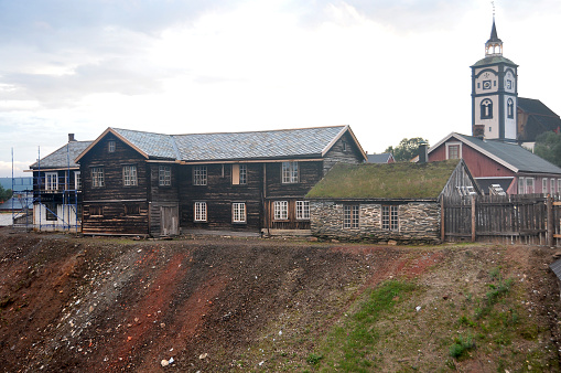 Røros, Norway - July 28, 2015: Old Brown wooden houses in front of the old church in the mining city Røros