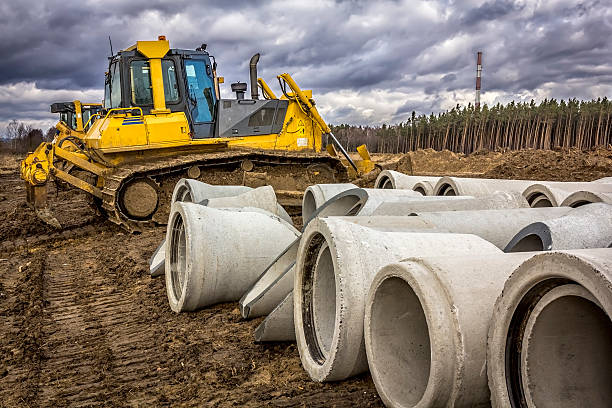 istock Concrete drainage pipes and bulldozers 510006644
