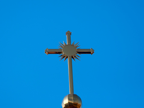 White christian stone cross in a cemetery in spring