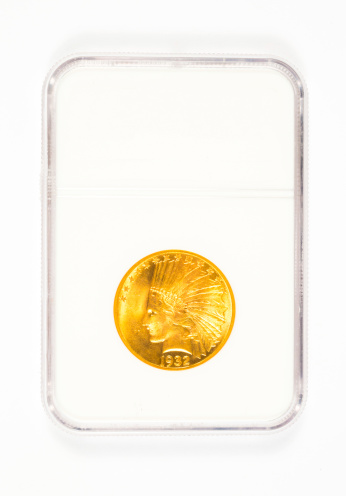 Antique gold coin in a collector's case after being graded.