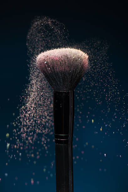 istock Professional black make-up brush with pink powder in motion 510011581