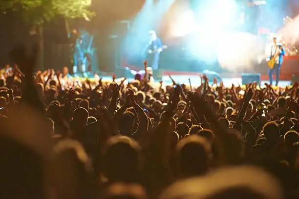 Rear view of a crowd of people watching their band perform beneath the strobe lights on stagehttp://195.154.178.81/DATA/i_collage/pi/shoots/782675.jpg