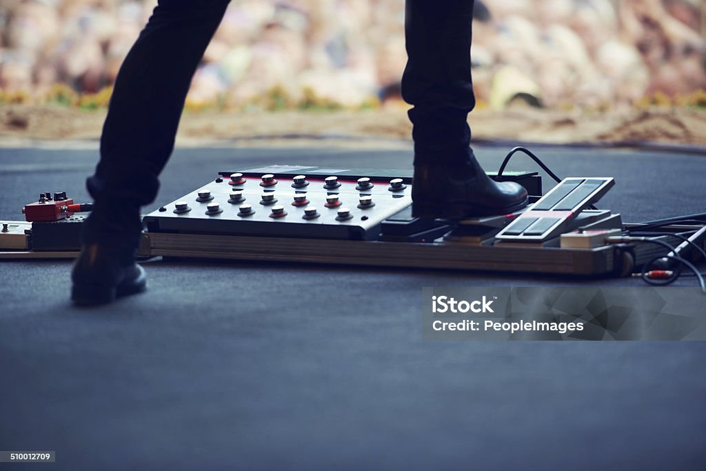 Bring the distortion! Cropped image of a performer pushing down on a distortion pedal on stagehttp://195.154.178.81/DATA/i_collage/pi/shoots/782677.jpg Concert Stock Photo