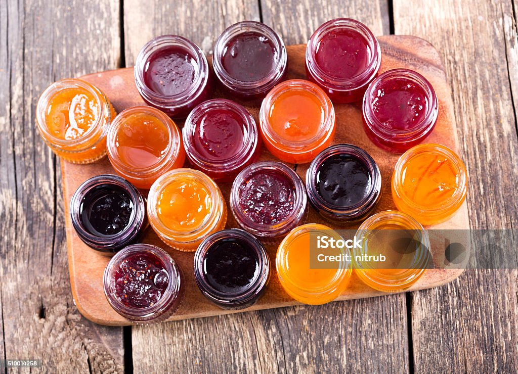 various jars of fruit jam various jars of fruit jam on wooden table Berry Fruit Stock Photo