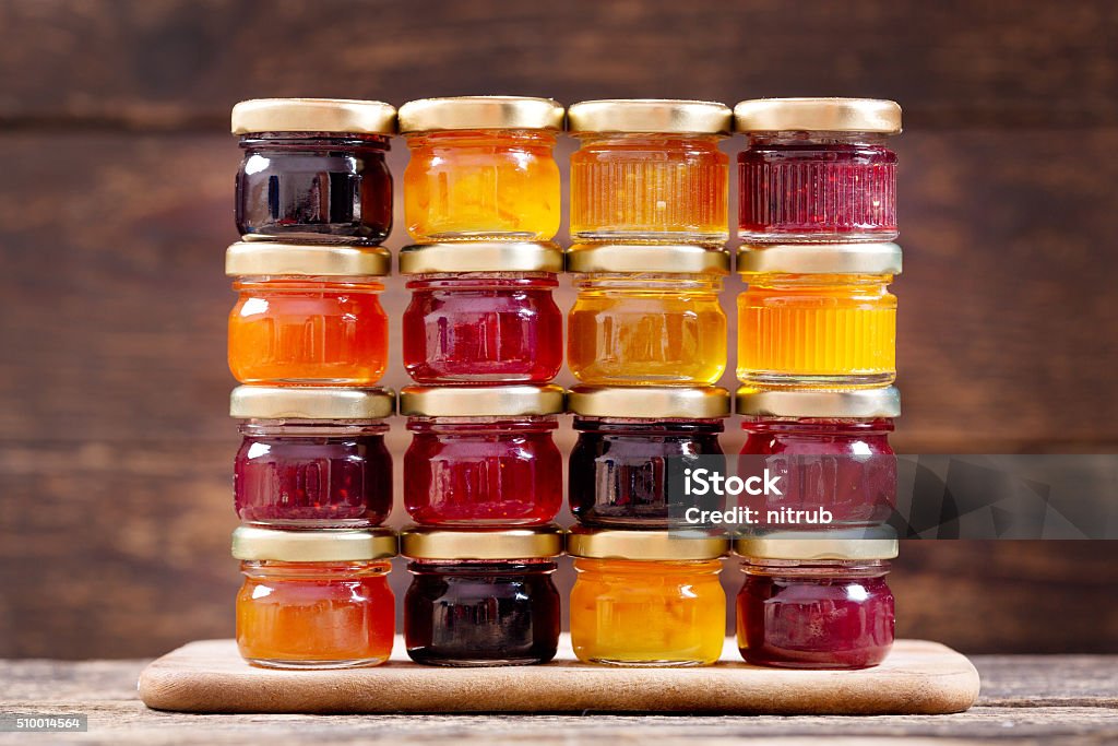 various jars of fruit jam various jars of fruit jam on wooden table Preserves Stock Photo